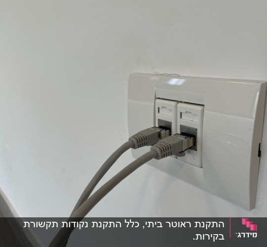 שני כבלי רשת מחוברים לשקע קיר לבן
